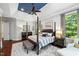 This main bedroom features stylish hardwood floors, a four-poster bed and lots of natural light at 7552 Hasentree Club Dr, Wake Forest, NC 27587