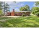 Manicured backyard features full brick home with a patio, perfect for enjoying outdoor living and entertaining at 780 Leslie Campbell Ave, Lillington, NC 27546