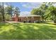 Expansive backyard features a well-maintained lawn and a full brick home with a patio for outdoor enjoyment at 780 Leslie Campbell Ave, Lillington, NC 27546