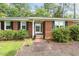 Close up of a charming brick home's entryway, complete with a brick walkway and black shutters at 780 Leslie Campbell Ave, Lillington, NC 27546