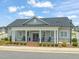 Community clubhouse featuring a welcoming entrance, charming rocking chairs, and professionally landscaped grounds at 797 S Wilma St, Angier, NC 27501