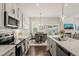 Bright kitchen with stainless steel appliances, granite counters, and an open dining area at 797 S Wilma St, Angier, NC 27501