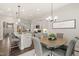 Open kitchen and dining area with modern lighting, stainless appliances, and ample seating at 797 S Wilma St, Angier, NC 27501