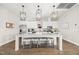 The kitchen features white cabinets, modern lighting, an island with bar stool seating, and stainless steel appliances at 797 S Wilma St, Angier, NC 27501