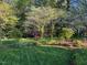 Lush backyard garden with mature trees and meticulously landscaped greenery for serene outdoor enjoyment at 1004 E Willowbrook Dr, Burlington, NC 27215