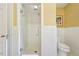 Bathroom featuring a glass-enclosed shower with white tiling and a matching toilet at 1004 E Willowbrook Dr, Burlington, NC 27215