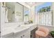 Bright bathroom featuring white tile, large mirror, vanity, and window at 1004 E Willowbrook Dr, Burlington, NC 27215