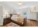 Bedroom with hardwood floors, a patterned rug, and a large window, well lit by lamp light at 1004 E Willowbrook Dr, Burlington, NC 27215
