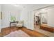 Sitting area just off the bedroom with hardwood floors, a comfortable chair, and walk-in closet at 1004 E Willowbrook Dr, Burlington, NC 27215