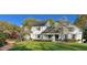 Charming two-story home featuring a well-manicured lawn, mature trees, and a welcoming front porch at 1004 E Willowbrook Dr, Burlington, NC 27215