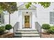 Elegant front entrance with stone steps, handsome wooden door, and manicured landscaping at 1004 E Willowbrook Dr, Burlington, NC 27215