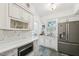 Bright kitchen with white cabinets, stainless steel appliances, and sleek countertops at 1004 E Willowbrook Dr, Burlington, NC 27215