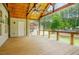 Large covered patio with views of the pool and surrounding trees at 1005 Hidden River Ct, Raleigh, NC 27614