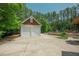 Garage with a two-car garage door, long driveway, and green foliage at 1005 Hidden River Ct, Raleigh, NC 27614