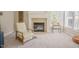 Cozy living room with a fireplace, comfortable armchair, and natural light from a large window at 1005 Hidden River Ct, Raleigh, NC 27614