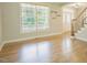 Bright living room with hardwood floors, large window, and elegant staircase at 1005 Hidden River Ct, Raleigh, NC 27614