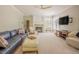 Cozy living room with a fireplace, plush seating, and abundant natural light at 1005 Hidden River Ct, Raleigh, NC 27614