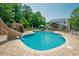 Backyard view of pool with stone pavers, slide and outdoor furniture at 1005 Hidden River Ct, Raleigh, NC 27614