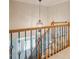 Elegant staircase with wood and iron railings, complemented by a decorative chandelier above at 1005 Hidden River Ct, Raleigh, NC 27614