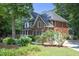 Beautiful two-story brick home with manicured lawn and lush landscaping in a serene, wooded setting at 101 Royal Glen Dr, Cary, NC 27518