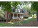 Charming two-story brick home with a welcoming front porch and well-maintained landscaping at 101 Royal Glen Dr, Cary, NC 27518