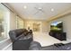Spacious living room with a large leather couch, entertainment center, and a view into a game room at 101 Royal Glen Dr, Cary, NC 27518