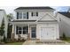 Charming two-story home featuring a well-manicured lawn and a cozy front porch at 103 Goldenrod Loop, Clayton, NC 27520