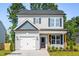 Charming two-story home with gray siding, a garage, and professionally landscaped yard at 103 Goldenrod Loop, Clayton, NC 27520