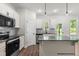Well-lit kitchen with an island, stainless steel appliances, and a door to the backyard at 103 Goldenrod Loop, Clayton, NC 27520