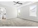 Tranquil main bedroom with carpeted floors, large windows, and a ceiling fan at 103 Goldenrod Loop, Clayton, NC 27520
