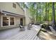 Spacious back deck with decorative seating and string lights, nestled among lush trees, perfect for outdoor entertaining at 107 Wimbledon Ct, Cary, NC 27511