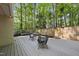 Relaxing back deck with outdoor furniture and wooden fence bordering a yard with tall trees, offering a serene setting at 107 Wimbledon Ct, Cary, NC 27511