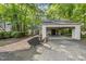 Exterior view featuring a long driveway leading to a carport framed by greenery with a brick walkway at 107 Wimbledon Ct, Cary, NC 27511