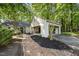 Property exterior showing a quaint home with a brick pathway leading to a covered carport and landscaped yard at 107 Wimbledon Ct, Cary, NC 27511