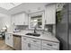 Bright kitchen showcasing white cabinetry, a stainless sink, and stylish backsplash at 107 Wimbledon Ct, Cary, NC 27511