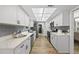 Modern kitchen featuring white cabinets, quartz countertops, and stainless steel appliances at 107 Wimbledon Ct, Cary, NC 27511