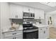 Updated kitchen with stainless steel appliances, white cabinets, and modern fixtures at 107 Wimbledon Ct, Cary, NC 27511