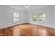 Bright bedroom featuring original hardwood flooring, two windows, ceiling fan and neutral walls at 1090 S Fifth St, Mebane, NC 27302