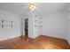 Bedroom with hardwood flooring, neutral paint, open shelving, and a view to another room at 1090 S Fifth St, Mebane, NC 27302
