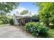 Home exterior with covered patio and carport, surrounded by trees and colorful hydrangea bushes at 1090 S Fifth St, Mebane, NC 27302