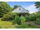 Charming home with abundant greenery and foliage covering the front exterior, offering a serene curb appeal at 1090 S Fifth St, Mebane, NC 27302
