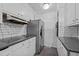 Galley kitchen featuring white cabinets, subway tile, and stainless steel appliances at 1090 S Fifth St, Mebane, NC 27302