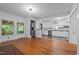 Open living room with hardwood floors next to a modern kitchen and large windows at 1090 S Fifth St, Mebane, NC 27302