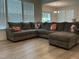 Spacious living room featuring a large gray sectional sofa and hardwood floors at 1116 Sidney Creek Dr # 1116, Zebulon, NC 27597