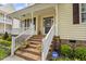 Inviting front porch with brick steps, white railings, and colorful flower accents at 121 Fort Jackson Rd, Morrisville, NC 27560