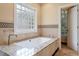 Bathroom boasts tub with granite surround, tile accents, and a window block for natural light at 1211 E Pointe Dr, Durham, NC 27712