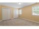 Bright bedroom with neutral carpet, natural light from windows and double door closet at 1211 E Pointe Dr, Durham, NC 27712