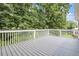 A spacious back deck with white railings offers a peaceful outdoor setting surrounded by trees at 1211 E Pointe Dr, Durham, NC 27712