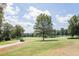 Scenic view of the lush green golf course with a golf cart on the winding cart path at 1211 E Pointe Dr, Durham, NC 27712
