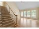 Bright living room with hardwood floors, staircase, and multiple windows at 1211 E Pointe Dr, Durham, NC 27712